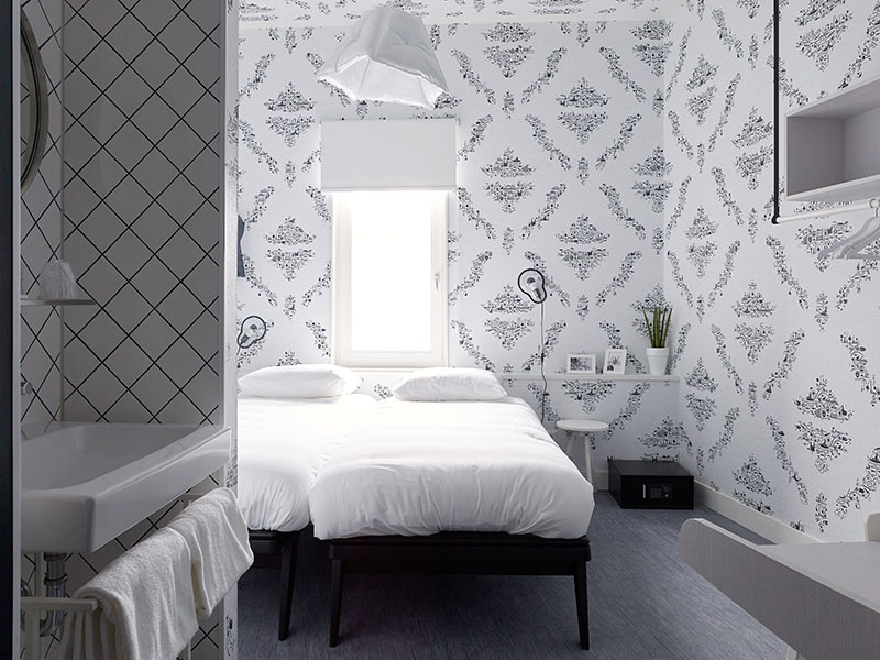 Lichte kamer met tweepersoonsbed, bijzettafel, kluis en raam| Kaboom Hotel