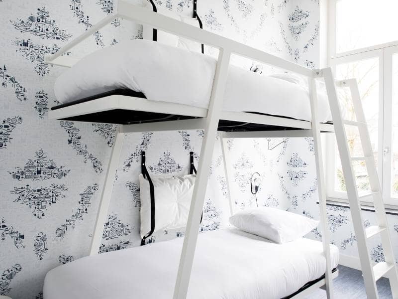 Stapelbed in lichte kamer en raam in het hoofdeinde | Kaboom Hotel
