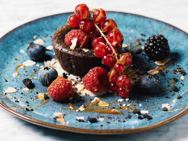 Plate with chocolate coulant and red berries | Kaboom Hotel